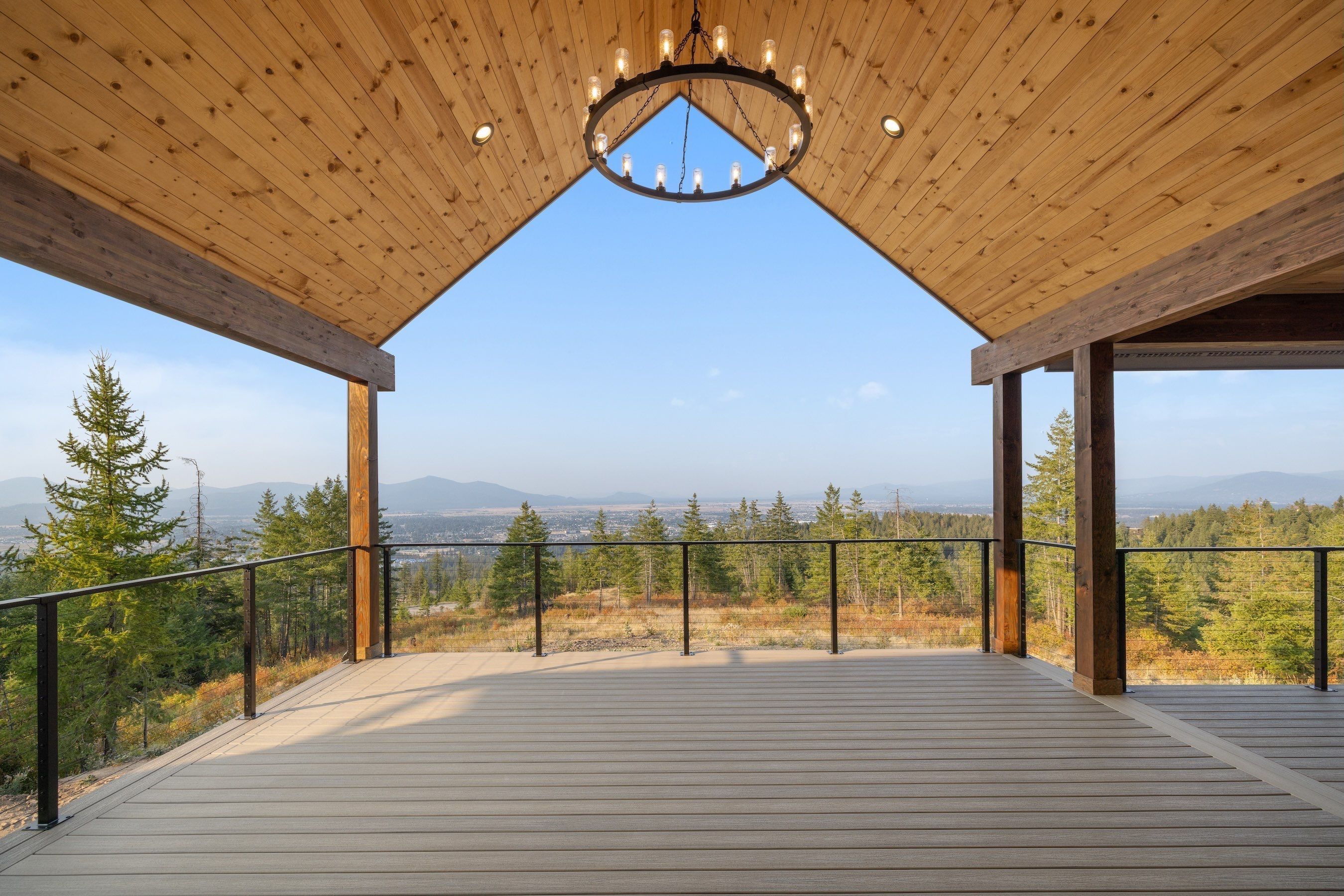 The covered deck at The Mountainside Retreat, a Post Falls custom home Onyx & Oak Homes built for owners in California